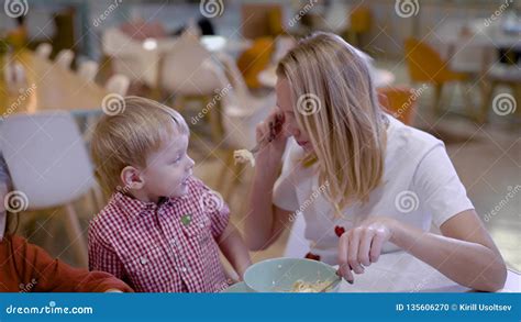 Beautiful Blonde Loving Mother With Son And Daughter Eating In Cozy Cafe On Weekends Stock