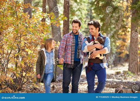 Coppie Maschii Gay Con I Bambini Che Camminano Attraverso Il Terreno Boscoso Di Caduta Immagine