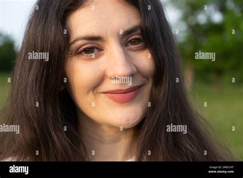 Portrait Of A Year Old Brunette Woman Looking At The Camera Smiling In Nature Stock Photo Alamy