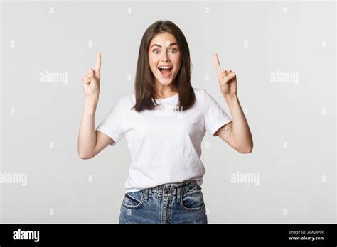 Attractive Smiling Brunette Girl Pointing Fingers Up Showing Logo Stock Photo Alamy