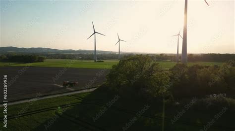 Vidéo Stock Large wind turbines with blades in field aerial a tractor