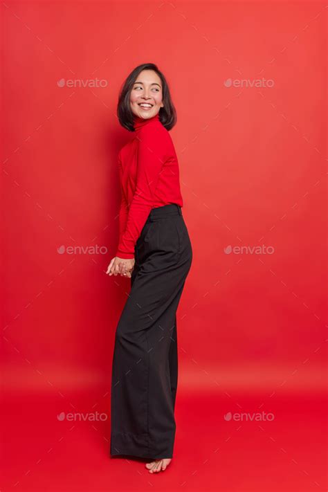 Indoor Shot Pleased Shy Brunette Asian Woman Keeps Hands Together Looks Back Smiles Happily