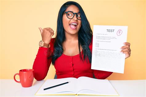 Bella Joven Latina Con El Pelo Largo Mostrando Un Examen Fallido Apuntando Hacia El Lado