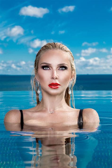 Beautiful Blonde Woman Model With Wet Hair And Elegant Makeup Sitting In A Pool Stock Image