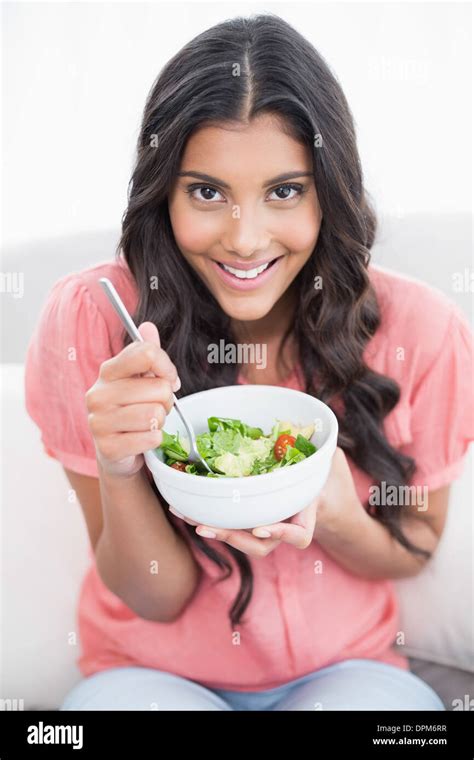 Cheerful Cute Brunette Sitting On Couch Holding Salad Bowl Stock Photo Alamy