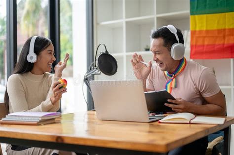 A Joyful Asian Gay Podcaster Or Radio Host Is Laughing Enjoying Interviewing His Guest Stock