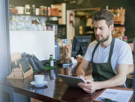 Simplifying Business with Technology. a Young Barista Using a Tablet in ...