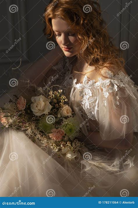 Beautiful Natural Redhead Girl Bride With Nude Makeup Wearing A White Dress Holds A Wedding