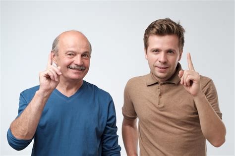 Premium Photo Portrait Of Two Serious Mature Men Father And Son With Warning Finger Against