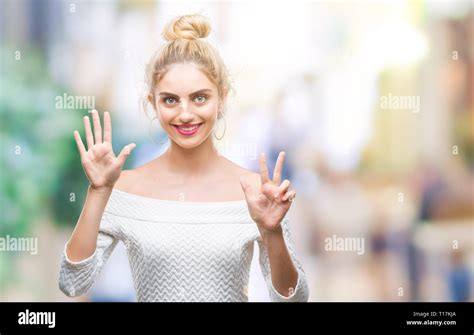 Belle jeune femme blonde aux yeux bleus sur fond isolés montrant et pointant vers le haut avec