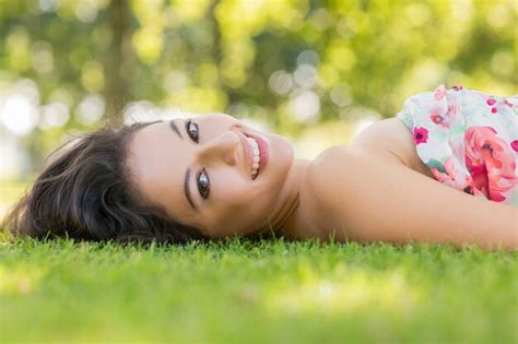 Premium Photo Stylish Smiling Brunette Lying On A Lawn
