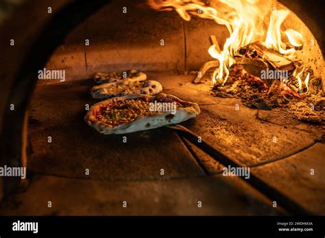 Traditional Oven For Baking Pizza With Burning Wood And Shovel The