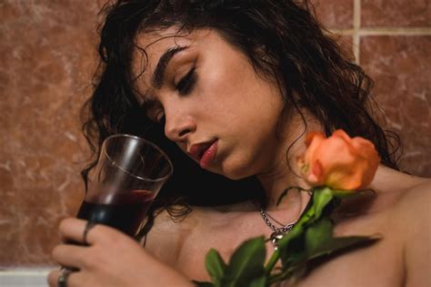 Premium Photo Attractive Naked And Woman In Bath With Glass Of Wine Holding A Rose Female