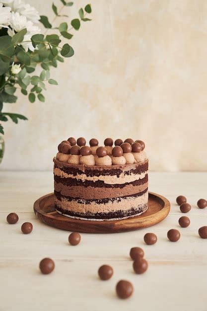 Premium Photo A Vertical Shot Of A Delicious Chocolate Naked Cake With Choco Balls And Cream