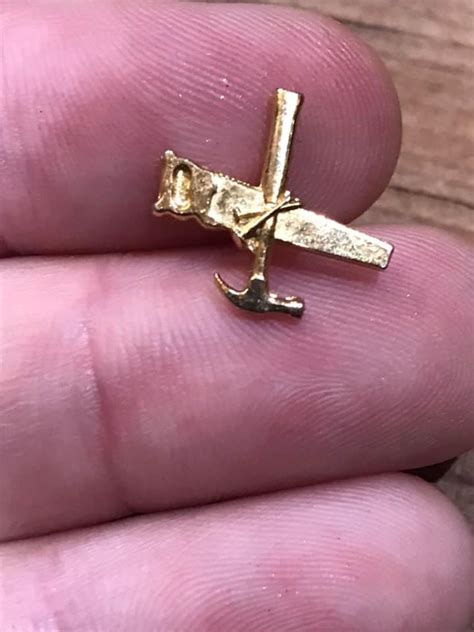Pair Of Little Gold Colored Pins Hammer Saw And Nails Antiques Board