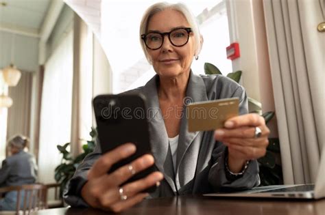 Gray Haired Mature Pretty Business Woman Dressed In A Stylish Gray Jacket Pays The Bill In A