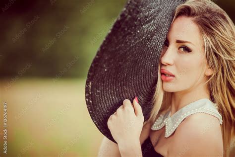 Attraktive Blonde Frau Mit Dem Schwarzen Hut Und Im Schwarzen Kleid Stock Photo Adobe Stock