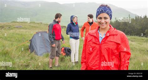 Brunette Smiling At Camera With Friends Behind Her On Camping Trip Stock Photo Alamy