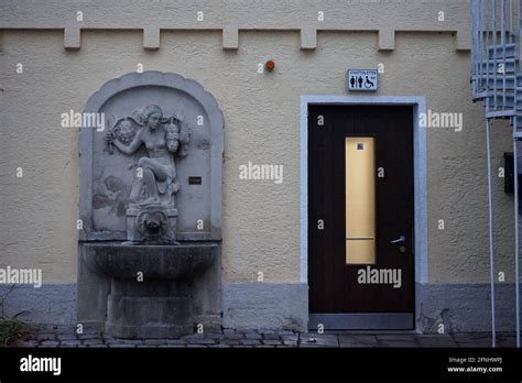 A Public Toilet With A Sculpture Embedded In The Wall Next To The