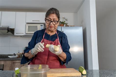 Adult Latina Woman In Her S Cutting Green Bananas To Make A Recipe From Latin America Ecuador