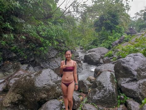 Premium Photo Portrait Of Smiling Bikini Woman Standing On Rock Against Trees In Forest