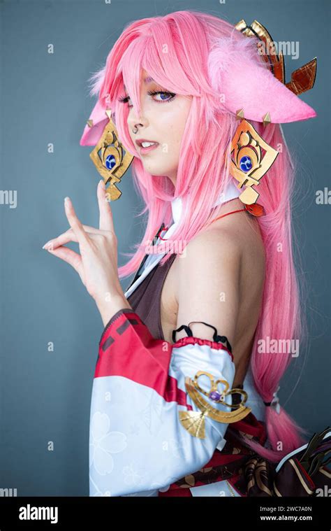 A Female cosplayer in a pink anime costume wearing pink hair Stock ...