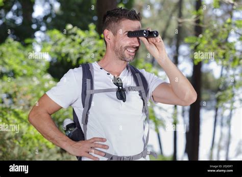 Man With Binoculars Standing In The Woods Stock Photo Alamy
