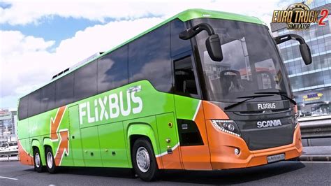 A Green And Orange Bus Driving Down A Street