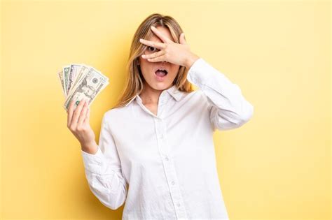 Jolie fille blonde semblant choquée effrayée ou terrifiée couvrant le