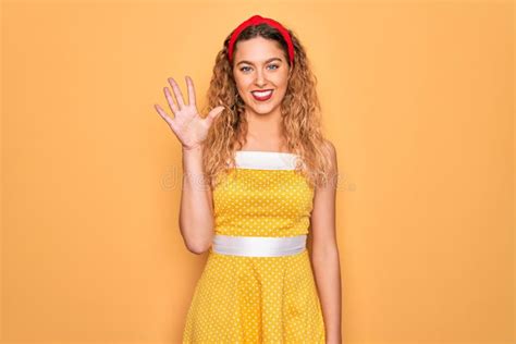 Belle Blonde Pinup Femme Aux Yeux Bleus Portant Diadem Debout Sur Fond Jaune Montrant Et