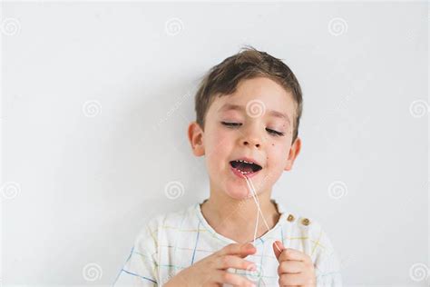 Cute Boy Pulling Loose Tooth Using A Dental Floss Process Of Removing