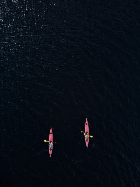 Premium Photo Aerial View Of Two Red Kayaks In Dark Blue Lake Water