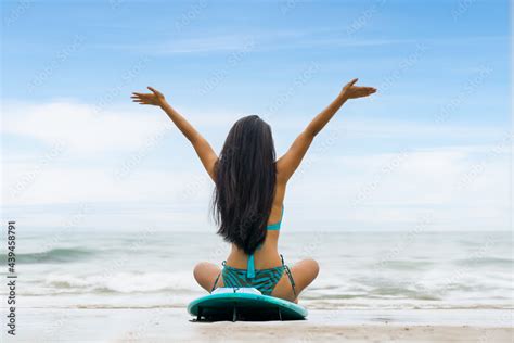 Woman Surfer In Bikini Sitting On Surfboard On Beach In Front Of Sea Stock Photo Adobe Stock