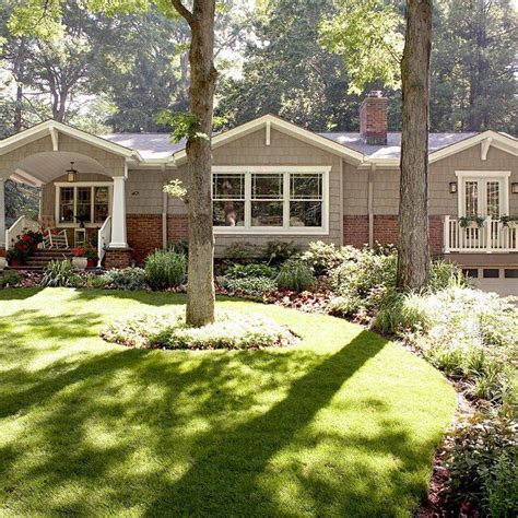 A House In The Woods With Lots Of Trees And Flowers On The Front Lawns