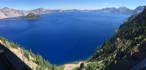 A Large Blue Lake Surrounded By Mountains And Trees