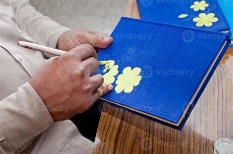 A Handicraft Artist Is Painting On A Handmade Book Cover In Home Studio