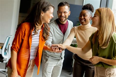 Jovens startups multiétnicos dão as mãos no escritório moderno Foto