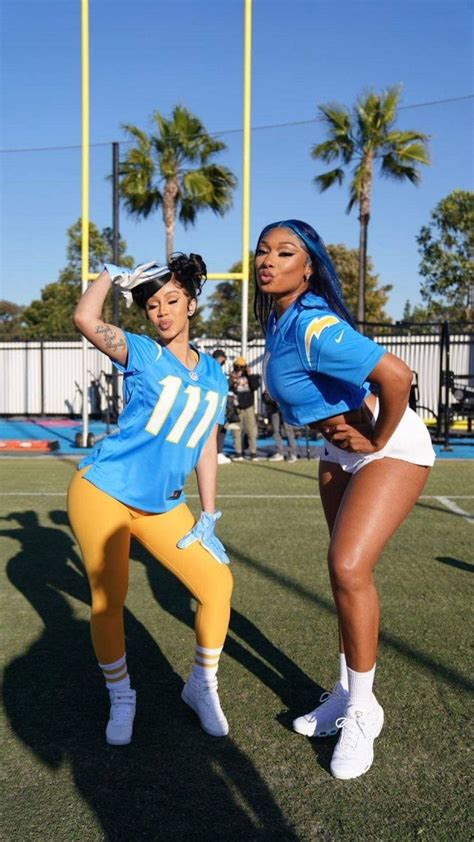 Two Women In Blue And Yellow Uniforms On A Football Field With Palm