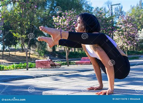 Cute Brunette Yoga Instructor Concentrating And Doing Tittibhasana Standing On Her Hands In The