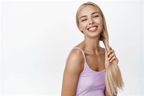 Bonne Fille Blonde Riant Et Souriant Touchant Des Cheveux Longs En Bonne Sant Et Regardant