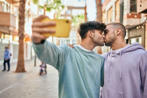 Pareja Joven Gay Besándose Y Haciéndose Selfie Por El Smartphone De La Ciudad Foto de archivo