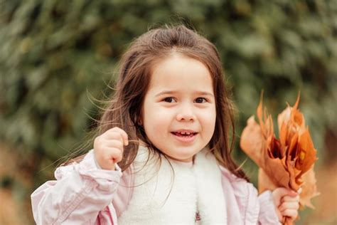 Premium Photo Portrait Of Cute Smiling Girl Holding Leaf