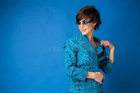 Fille Du Caucase Gay Attirante Avec Les Cheveux Foncés Tir Isolé Sur Le Fond Bleu Photo stock