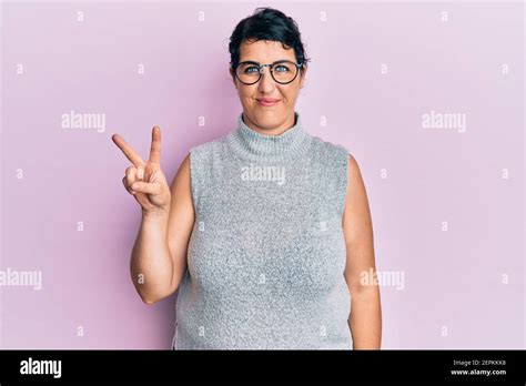 Plus Size Brunette Woman Wearing Casual Clothes And Glasses Smiling With Happy Face Winking At