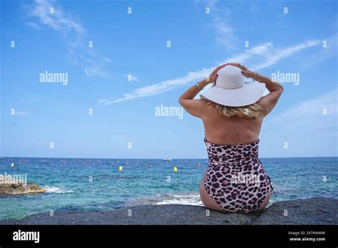 Rear View Of Adult Female Tourist In Bikini Looking At Ocean Summertime In Holidays Stock Photo