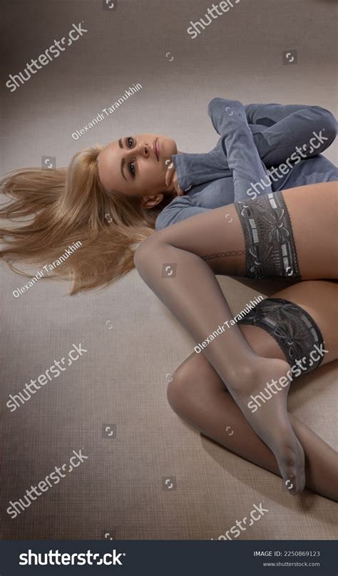 Beautiful Blonde Model With Perfect Legs In Pantyhose And Shoes Posing Over Royalty Free