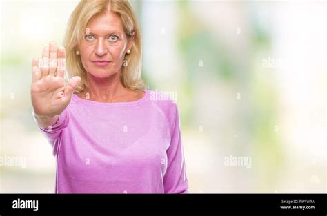 Blonde Frau mittleren Alters über isolierte Hintergrund tun halt Singen mit der Hand Warnung