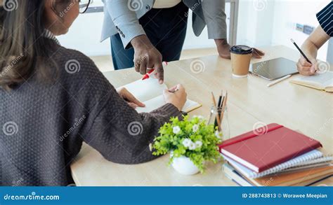 Mature Professor Talking To His Student While Assisting Her On A Class At The University Stock
