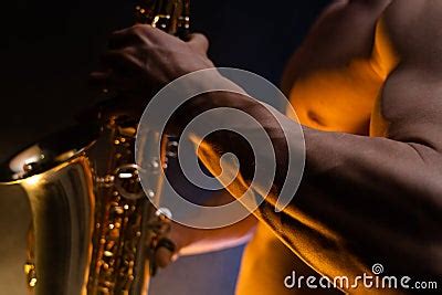Muscular Man Naked Torso Playing On Saxophone With Smoked Colorful Background Royalty Free Stock