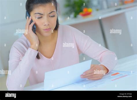 Attractive Brunette On Phone With Worried Facial Expression Stock Photo Alamy
